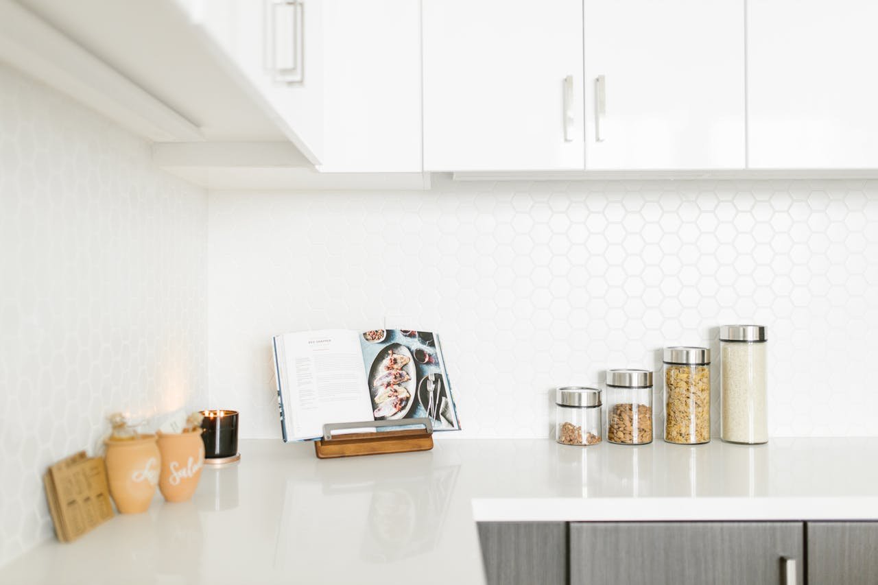 services-04 Bright minimalist kitchen interior showcasing decor and storage jars on a sleek countertop.