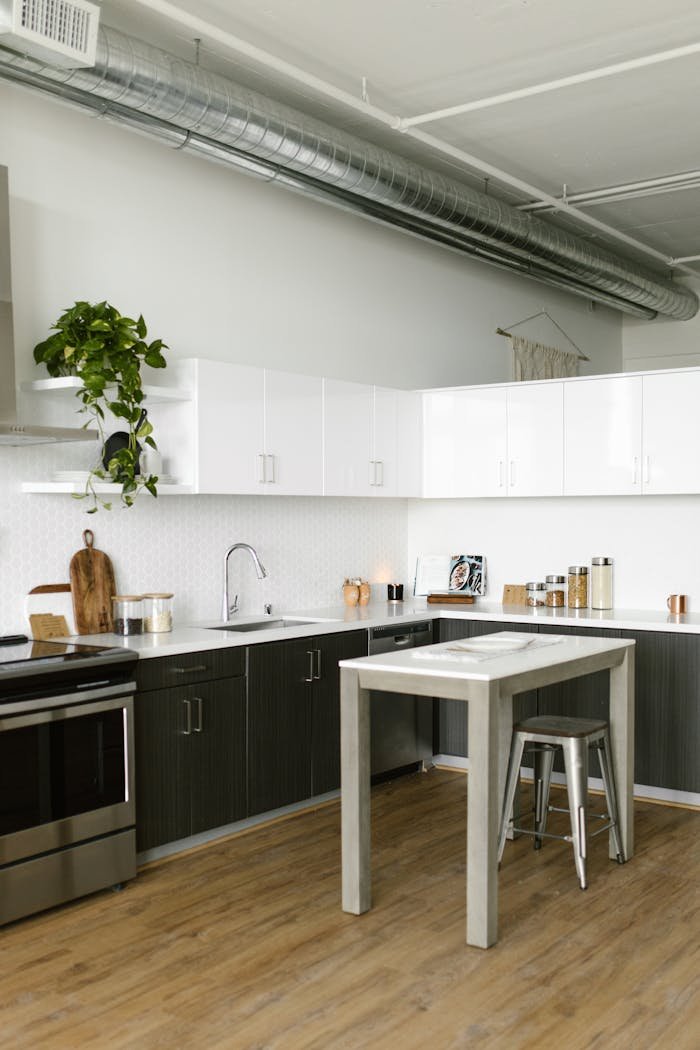 about-01 A stylish, minimalistic kitchen featuring industrial design elements and modern furnishings.
